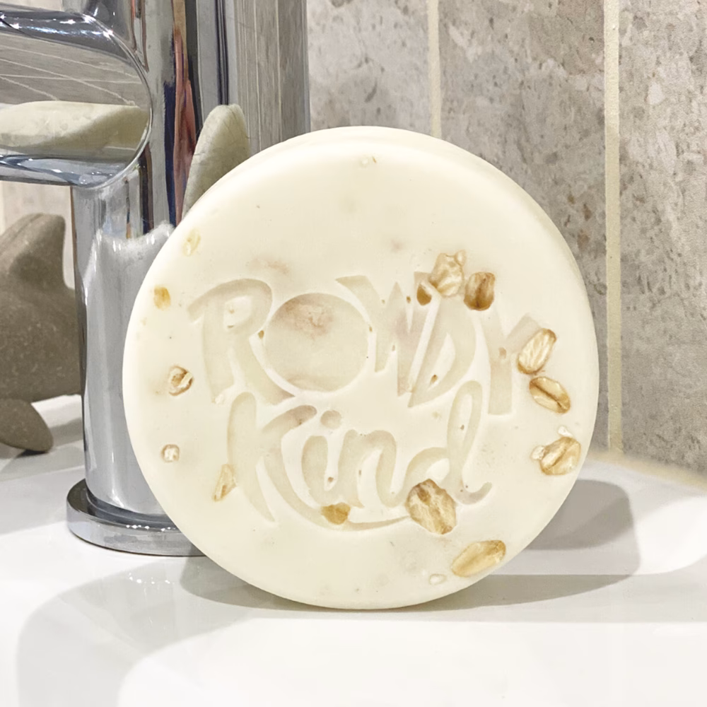Round soap with embossed text and oats.