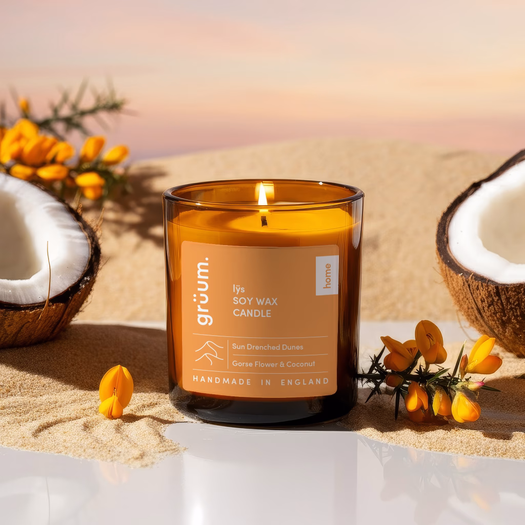 Candle and coconuts on sand
