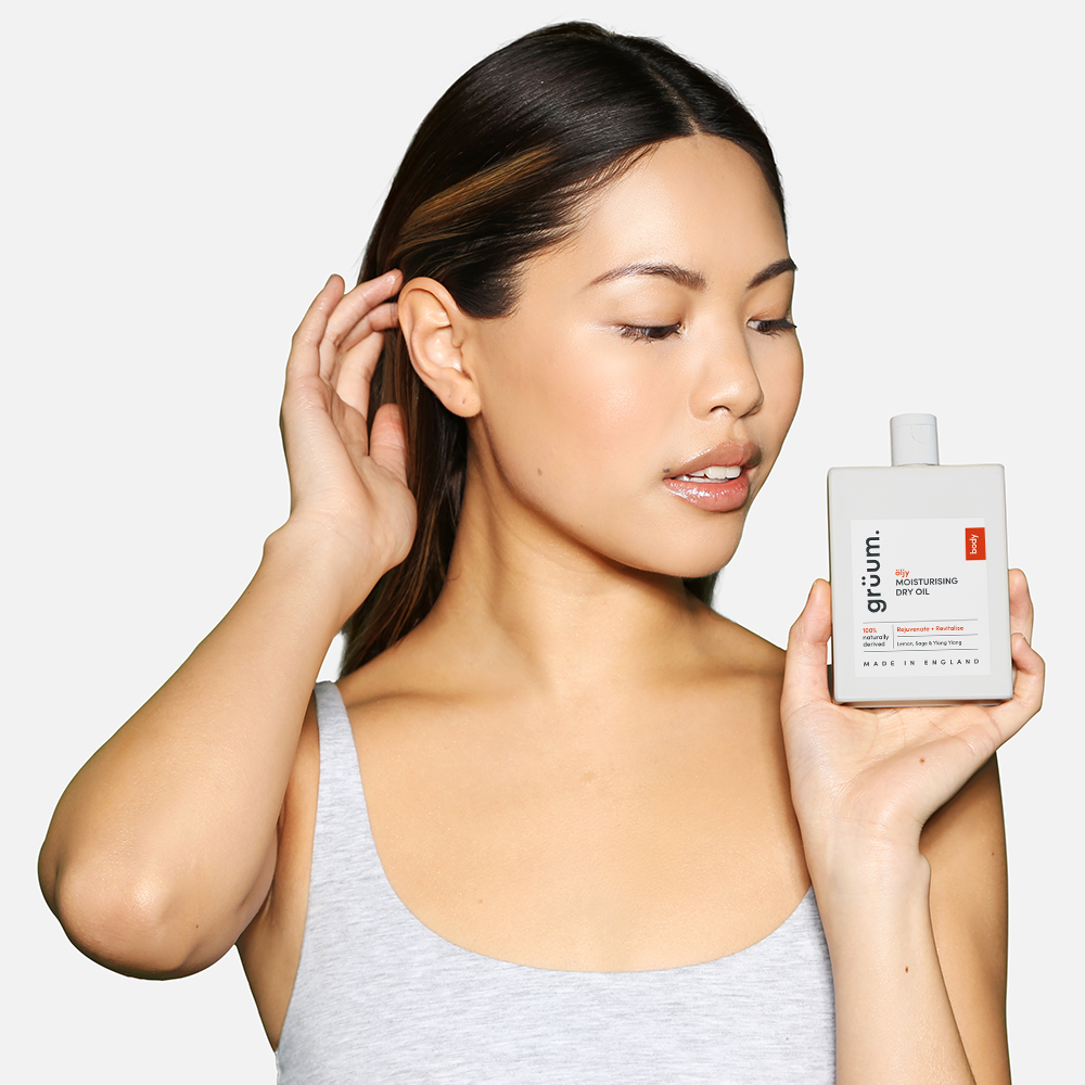 Woman holding gruum moisturising dry oil bottle.