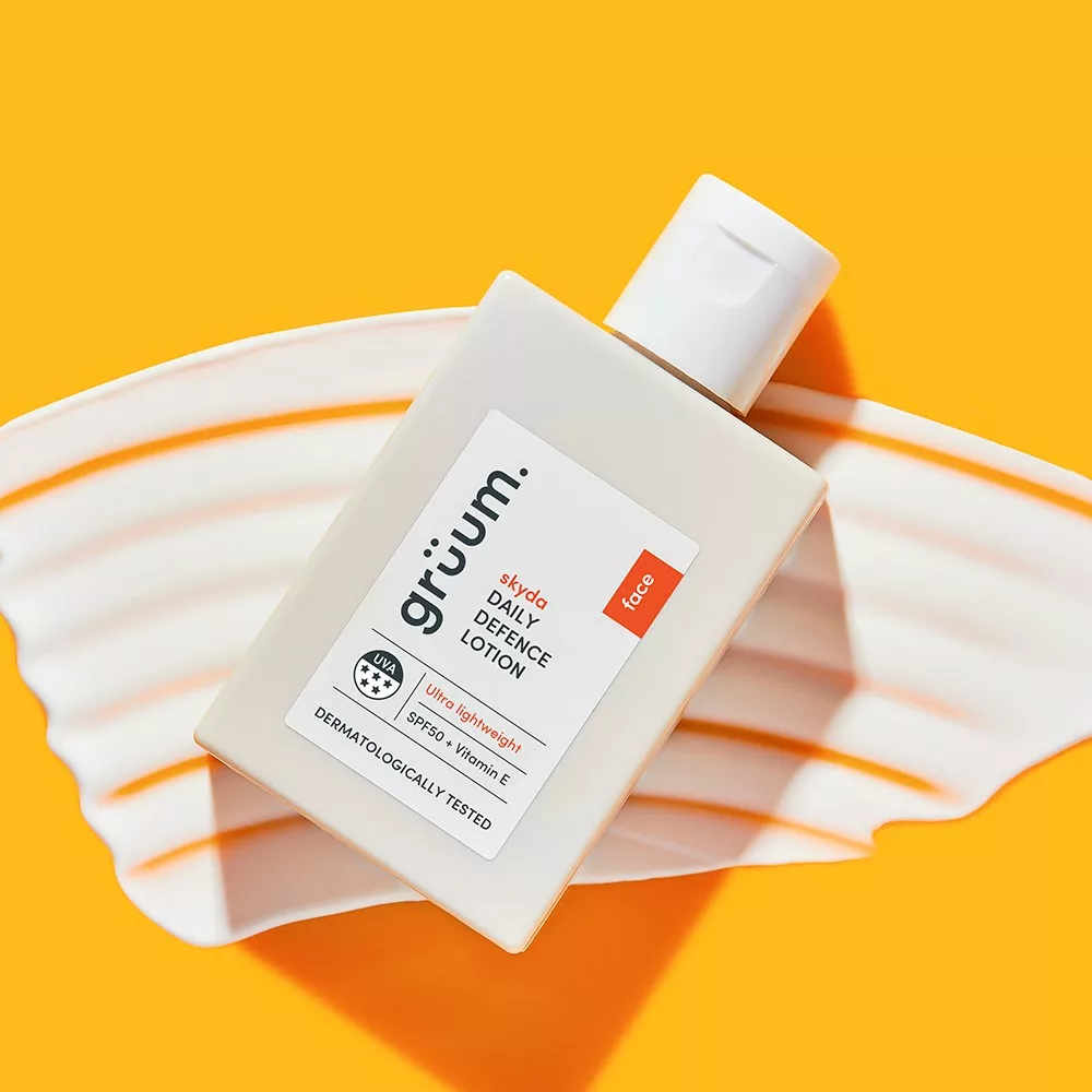 Daily defense lotion on orange background.